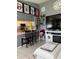 Living area open to kitchen featuring breakfast bar, television, and sports memorabilia at 18607 Bent Pine Dr, Hudson, FL 34667