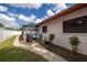 Backyard view of the house featuring a stone path, grill, and a screened-in pool area at 1874 Cameo Way, Clearwater, FL 33756
