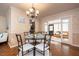 Elegant dining room featuring a glass table, wrought iron chairs, and decorative chandelier lighting at 1874 Cameo Way, Clearwater, FL 33756