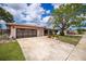 Charming single-story home featuring a well-kept lawn, mature trees and a two-car garage at 1874 Cameo Way, Clearwater, FL 33756