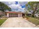 Charming single-story home featuring a well-kept lawn, mature trees and a two-car garage at 1874 Cameo Way, Clearwater, FL 33756