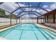 Inviting in-ground pool with a screened enclosure, perfect for outdoor enjoyment and relaxation with a white fence at 1874 Cameo Way, Clearwater, FL 33756