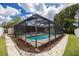 Enclosed screened in pool with stone path and landscaping, creating a private backyard oasis at 1874 Cameo Way, Clearwater, FL 33756