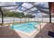 Enclosed screened-in pool with clear blue water and brick pavers, offering a private backyard retreat at 1874 Cameo Way, Clearwater, FL 33756