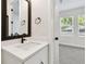 Stylish bathroom with a dark-framed mirror, quartz countertop, and an adjacent bedroom with plenty of natural light at 2121 1St N Ave, St Petersburg, FL 33713