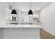 Well-lit kitchen boasts an island, white cabinetry, modern lighting, and stainless steel appliances at 2121 1St N Ave, St Petersburg, FL 33713