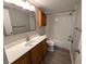 Bathroom featuring a vanity with a solid surface countertop, a tub with white tiled surround, and wood cabinets at 2306 Hammock Pine Blvd # 2306, Clearwater, FL 33761