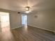 Neutral bedroom featuring light hardwood floors, a ceiling fan, and views to the bathroom at 2306 Hammock Pine Blvd # 2306, Clearwater, FL 33761