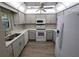 Modern kitchen with white appliances, gray cabinets, quartz countertops, and ample natural light at 2306 Hammock Pine Blvd # 2306, Clearwater, FL 33761
