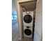 Convenient laundry closet with stacked washer and dryer units and built-in shelving at 2306 Hammock Pine Blvd # 2306, Clearwater, FL 33761