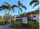 Community pool entrance with visible pool rules, palm trees, and secure iron fencing at 2306 Hammock Pine Blvd # 2306, Clearwater, FL 33761