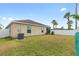 Large, green backyard with privacy fence, palm trees, and well-maintained lawn at 2404 Dovesong Trace Dr, Ruskin, FL 33570