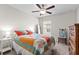 Bright bedroom with colorful quilt, ceiling fan, and neutral walls and carpet at 2404 Dovesong Trace Dr, Ruskin, FL 33570