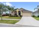Charming single-story home with a manicured front yard, lush landscaping, and a two-car garage at 2404 Dovesong Trace Dr, Ruskin, FL 33570