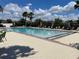 Community pool with lounge chairs surrounded by brick pavers and palm trees at 2404 Dovesong Trace Dr, Ruskin, FL 33570