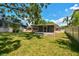 A lovely backyard featuring a screened-in patio and green grass for outdoor entertainment at 2607 S Bryant Cir, Tampa, FL 33629
