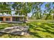 View of a large backyard with a screened-in lanai, mature trees, and plenty of room for outdoor enjoyment at 2607 S Bryant Cir, Tampa, FL 33629