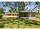 Large backyard featuring a screened-in lanai, a lush green lawn, mature trees, and plenty of outdoor space for Gathering fun at 2607 S Bryant Cir, Tampa, FL 33629