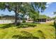 The shady backyard highlights a covered patio area for relaxing in the outdoors on a sunny day at 2607 S Bryant Cir, Tampa, FL 33629
