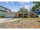 Front exterior of a single-story home featuring a two car garage and a front porch at 2607 S Bryant Cir, Tampa, FL 33629