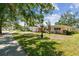 Front exterior of home, highlighting the home's vintage charm, landscaping, and well-maintained lawn at 2607 S Bryant Cir, Tampa, FL 33629