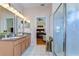 Bathroom with double sinks, wood cabinets, a walk-in shower, and view to the bedroom at 2816 Graphite Ct, Valrico, FL 33594