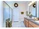 Bright bathroom with double sinks, granite countertops, and a glass-enclosed shower at 2816 Graphite Ct, Valrico, FL 33594