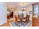 Formal dining room featuring wood table, chandelier, plantation shutters, and blue accent rug at 2816 Graphite Ct, Valrico, FL 33594