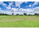 Scenic view of the golf course featuring lush green grass, scattered trees, and a blue sky at 2816 Graphite Ct, Valrico, FL 33594