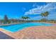 Large community pool with lounge chairs, palm trees, and a clear blue sky at 2816 Graphite Ct, Valrico, FL 33594