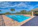 Large community pool with lounge chairs, palm trees, and a clear blue sky at 2816 Graphite Ct, Valrico, FL 33594