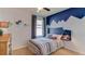 Comfortable bedroom featuring a mountain-themed accent wall, stylish decor, and plenty of natural light at 2967 Gardiner Ln, Zephyrhills, FL 33541
