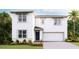 Two-story home featuring an attached garage and a well-manicured lawn and landscaping at 32706 Osprey Peak Way, San Antonio, FL 33576