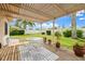 Cozy covered backyard patio with a dining set, lush plants, and tranquil outdoor space at 3360 Masters Dr, Clearwater, FL 33761