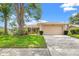 Charming single-story home featuring a well-manicured lawn, mature tree, and two-car garage at 3360 Masters Dr, Clearwater, FL 33761