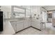 White kitchen with expansive windows, tile flooring, and updated appliances at 3360 Masters Dr, Clearwater, FL 33761