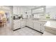 Bright kitchen featuring white cabinets, an appliance package and tile floors at 3360 Masters Dr, Clearwater, FL 33761