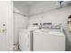 Functional laundry room equipped with a washer, dryer, and storage shelf at 3360 Masters Dr, Clearwater, FL 33761