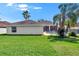 A spacious backyard offers a private oasis with lush green grass and swaying palm trees at 3505 Kilmer Dr, Plant City, FL 33566