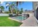 Spacious backyard featuring a fenced pool, lush lawn, and mature palm trees at 3505 Kilmer Dr, Plant City, FL 33566