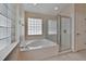 Bright bathroom featuring a soaking tub with glass block windows and a separate glass-enclosed shower at 3505 Kilmer Dr, Plant City, FL 33566