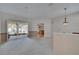 Open living space featuring neutral carpet, sliding glass doors, and a view into the kitchen at 3505 Kilmer Dr, Plant City, FL 33566