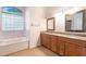 Large bathroom with double vanity, soaking tub, and updated fixtures at 3545 E Lake Dr, Land O Lakes, FL 34639