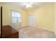 Well-lit bedroom featuring a window with white curtains, light yellow walls, and a closet with bi-fold doors at 3545 E Lake Dr, Land O Lakes, FL 34639