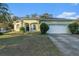 A single-story home with green paint, a well-manicured lawn, and an attached two-car garage at 3545 E Lake Dr, Land O Lakes, FL 34639