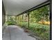Covered patio featuring a concrete floor and overgrown landscape at 3545 E Lake Dr, Land O Lakes, FL 34639