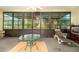 Sunroom featuring an abundance of windows, tiled floor, table, and a cushioned lounge chair at 3545 E Lake Dr, Land O Lakes, FL 34639