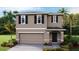 Charming two-story home featuring a symmetrical facade, neutral color palette, and well-maintained landscaping at 36130 Sunflower Hill Dr, Zephyrhills, FL 33541