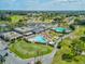 An aerial view showcasing the community pool, putting green, parking area, and nearby residential properties at 3681 Trophy Blvd # 6, New Port Richey, FL 34655