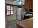 Bright kitchen with wood cabinets, white appliances, and tiled flooring at 38243 Ironwood Pl, Zephyrhills, FL 33542